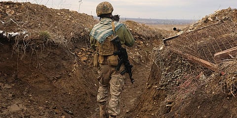 A Ukrainian soldier holds a cat and walks in a trench on the line of separation from pro-Russian rebels near Debaltsevo, Donetsk region, Ukraine, Ukraine Friday, Dec 3, 2021. (Photo | AP)