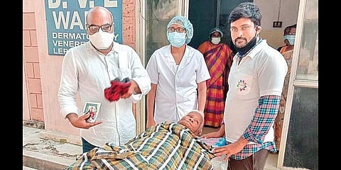 Satyanarayana and his friends help an elderly orphan woman at Kakinada government general hospital. (Photo | Express)