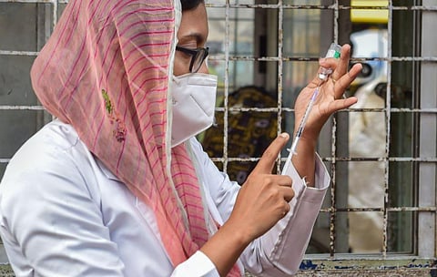 A health worker administers a dose of COVID-19 vaccine to a beneficiary at K R Market, amid possible threat for spread of Omicron variant of COVID-19. (Photo | PTI)