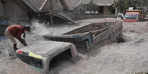 A man inspects a truck buried in the ash following the eruption of Mount Semeru in Lumajang district, East Java province, Indonesia, Sunday, Dec. 5, 2021. (Photo | AP)