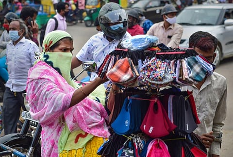 People buys face masks at K R Market amid fear of spread of the Omicron variant of COVID-19, in Bengaluru. (Photo | PTI)