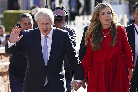 FILE - Britain's Prime Minister Boris Johnson waves to the media as he walks to the convention centre with his wife Carrie Johnson. (Photo | AP)