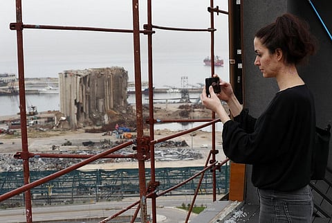 Joana Dagher, 33, who lost her memory for two full months from the trauma she suffered in the massive explosion at the Beirut port, takes pictures from her damaged apartment. (Photo | AP)