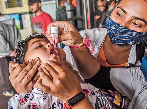 A child being administered polio drops by a health worker at Bhubaneswar railway station on Sunday. (Photo | EPS)