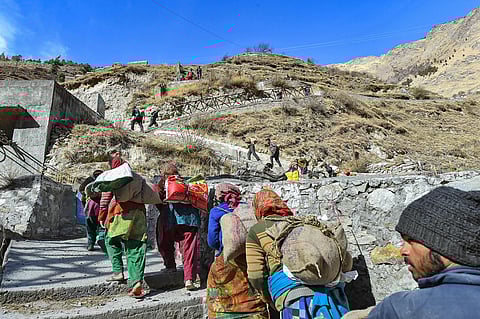 Flood-affected villagers of Bhalla gaon after receiving relief material from authorities in Chamoli district of Uttarakhand Friday. (Photo | PTI)