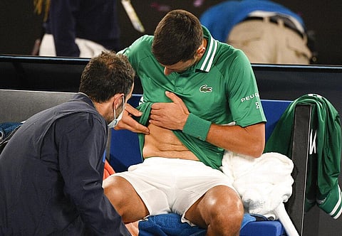 Serbia's Novak Djokovic receives treatment during his third round match against United States' Talyor Fritz (Photo |AP)