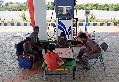 Employees of a petrol pump and their children play carrom at a filling station on Poonamallee highway in Chennai during lockdown in this file photo. ( Martin Louis, EPS)