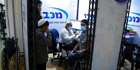 An Israeli man receives a Pfizer-BioNTech COVID-19 vaccine during an event to encourage the vaccination of young Israelis at a vaccination centre. (Photo | AP)