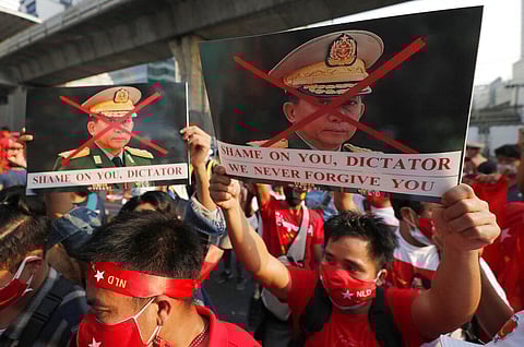 Burmese living in Thailand hold pictures of Myanmar military Commander-in-Chief Senior Gen. Min Aung Hlaing during a protest in front of the Myanmar Embassy in Bangkok. (Photo | AP)