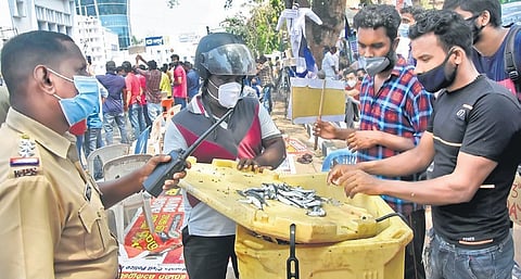 A police officer intervenes when aspirants in the PSC civil police officer rank list tried to sell fish as a mark of protest, in front of the Secretariat on Friday | B P Deepu
