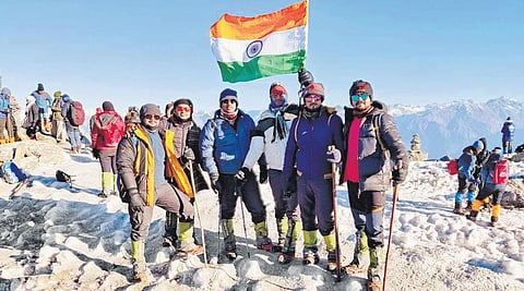 Rohan and his fellow trekkers from Odisha waving the national flag at Kedarkantha summit