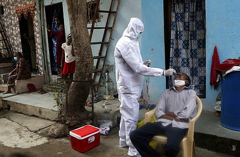 A health worker collects swab samples during a door-to-door screening for COVID-19 people at Dharavi, one of Asia's largest slums, in Mumbai, India. (Photo | AP)
