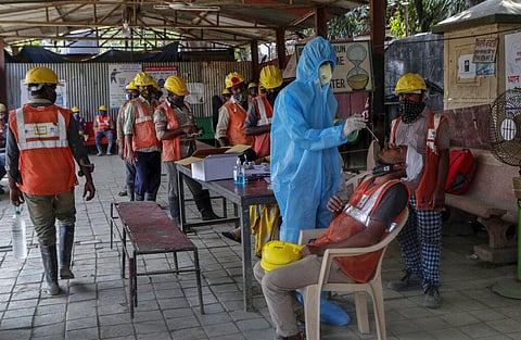 A health worker collects swabs of metro railway project workers to test for COVID-19 in Mumbai, India, Thursday, Feb. 25, 2021. (Photo | AP)