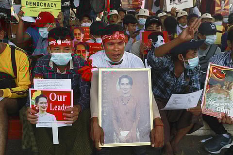 Protesters display images of deposed Myanmar leader Aung San Suu Kyi as they take part in a demonstration against the military coup in Yangon. (Photo | AP)