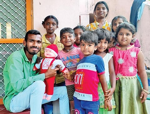 Ganesh demonstrates the interactive sensor doll to a group of children.