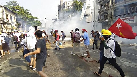 In this image from a video, anti-coup protesters react as smoke from tear gas rises in Yangon, Myanmar Sunday, Feb. 28, 2021. (Photo | AP)