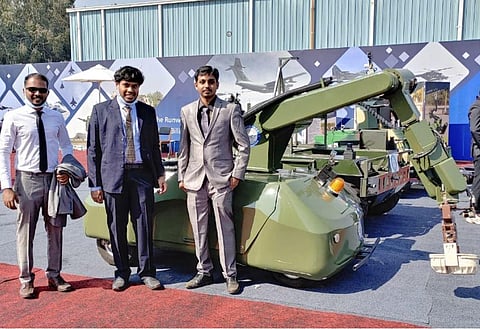 Vibhakar (L) Abhi Vignesh (C) and Vignesh at the Aero show in Bengaluru posing in front of Unmanned Ground Vehicle (Photo | EPS)