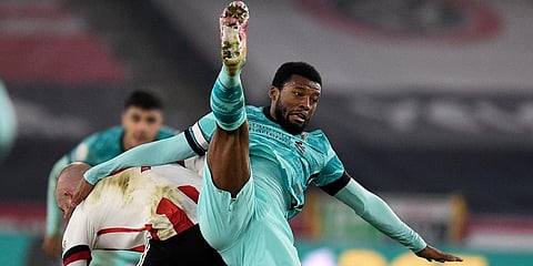 Liverpool's Georginio Wijnaldum lands on the back of Sheffield United's Oliver McBurnie during the EPL match at Bramall Lane stadium in Sheffield. (Photo | AP)