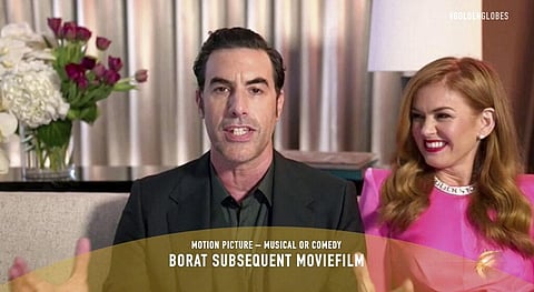 In this video grab issued by NBC, Sacha Baron Cohen, left, accepts the award for best picture, musical or comedy, for 'Borat Subsequent Moviefilm' as his wife Isla Fisher looks on. (Photo | AP)