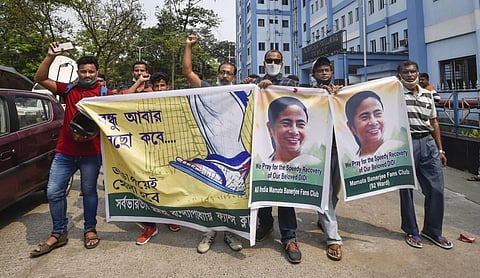 Trinamool Congress supporters pray for the speedy recovery of party chief and West Bengal CM Mamata Banerjee outside SSKM hospital in Kolkata. (Photo | PTI)