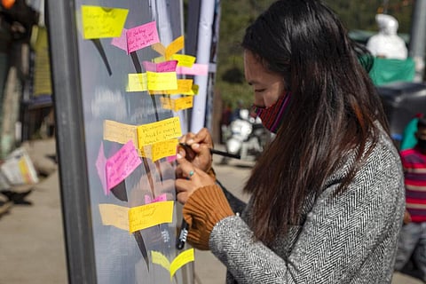 An exile Tibetan writes her message which challenges gender stereotypes on a on a piece of paper during a gathering to mark the International Women's Day in Dharmsala, India. (Photo | AP)