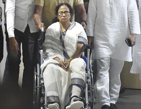 West Bengal Chief Minister Mamata Banerjee sitting in a wheel-chair being discharged from SSKM Hospital in Kolkata Friday March 12 2021. (Photo | PTI)