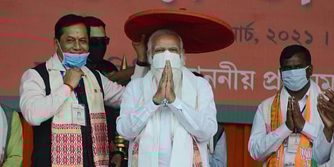 PM Narendra Modi being presented an 'Assamese Japi' by Assam CM Sarbananda Sonowal during a public rally ahead of Assam Polls (Photo | PTI)