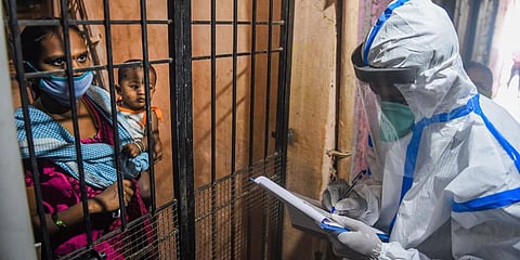 A health worker interacts with a resident of Dharavi slum during door-to-door screening for COVID-19 testing, in Mumbai (Photo | PTI)