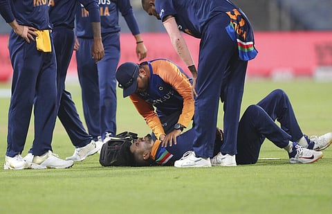 Shreyas Iyer, on ground, grimaces in pain after injuring himself while fielding during the first ODI at Pune. (Photo | AP)