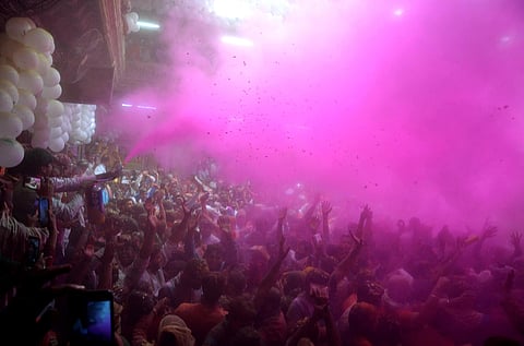 Devotees celebrate Holi ahead of the upcoming festival at Bankey Bihari temple, in Vrindavan on Wednesday evening. (Photo | ANI)