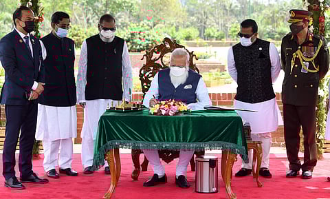Prime Minister Narendra Modi signs the visitors' book at National Martyrs' Memorial, Savar in Dhaka on Friday. (Photo | ANI)