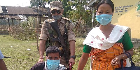 A security personnel helping a man in wheelchair to cast his vote (Photo by special arrangement)