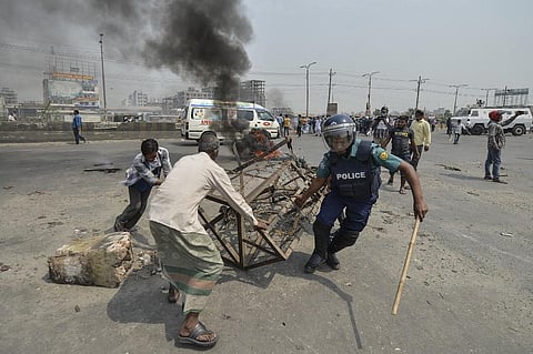 Police personnel remove a barricade after a clash with activists from Hefazat-e Islam during a nationwide strike following deadly clashes. (Photo| AFP)