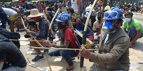 Anti-coup protesters prepare makeshift bow and arrows to confront police in Thaketa township Yangon, Myanmar. (Photo | AP)