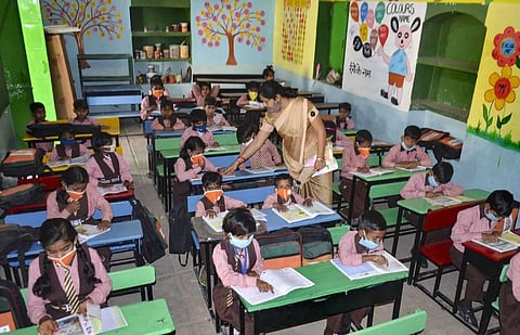 Students wearing masks attend a class after schools resumed for the students of classes 1st to 5th with certain COVID-19 safety guidelines. (Photo | PTI)
