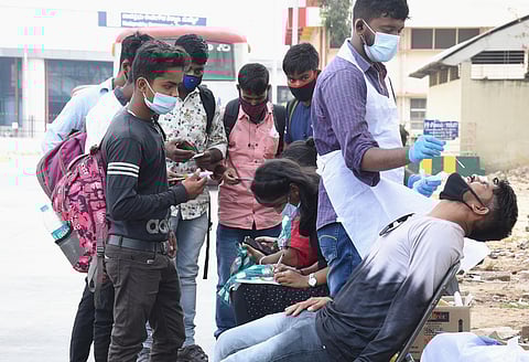 Health worker collects a sample at Majestic Bus Stand. (Photo | Vinod Kumar T, EPS)