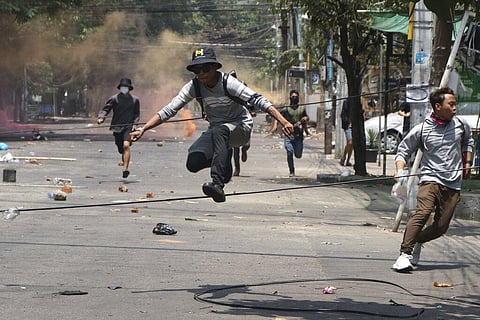 Anti-coup protesters run to avoid military forces during a demonstration in Yangon, Myanmar (Photo | AP)