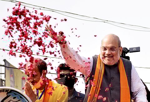 Union Home Minister Amit Shah throws flower petals during a roadshow ahead of the second phase of Assembly elections at Debra, in West Medinipur. (Photo | ANI)