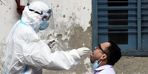 A health worker collects swab sample from a man for coronavirus rapid antigen and RT-PCR testing. (Photo | Parveen Negi, EPS)