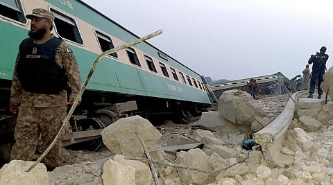 Army, police and rescue workers gather at the site of a derailed train in near Rohri, in southern Pakistan, Sunday. (Photo | AP)