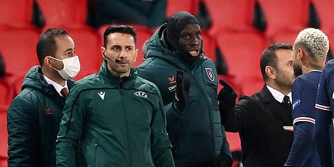 Romanian fourth official Sebastian Coltescu (C) looks on next to Istanbul Basaksehir's French forward Demba Ba (R) during the UEFA Champions League. (Photo | AFP)