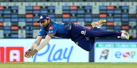 Mumbai Indians captain Rohit Sharma dives to field the ball during Vivo Indian Premier League 2021 match against RCB. (Photo | PTI)