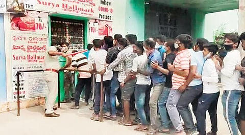 Moviegoers stand in a queue at the ticket counter in violation of Covid norms