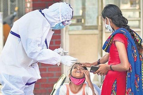 A health worker collects a sample from a young passenger for an RT-PCR test at Majestic Bus Terminal on Saturday | shriram BN