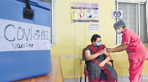 A health worker administers a Covid vaccine to a woman at KC General Hospital in Bengaluru on Sunday. (Photo | Shriram BN/EPS)