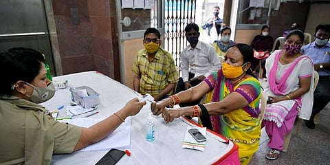 People undergo thermal screening as they wait for their turn to get the dose of the COVID-19 vaccine, at a local health centre in New Delhi. (Photo | ANI)