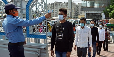 Devotees stand in a queue as they undergo thermal screening amid the surge in COVID-19 cases, at Prem temple in Vrindavan. (Photo | ANI)