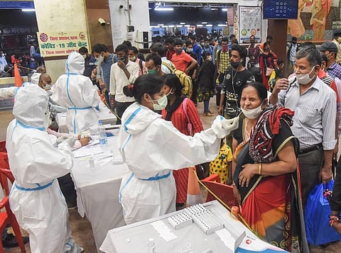 Health workers conduct COVID-19 testing of passengers arriving from Maharashtra at Patna Railway Station. (Photo | PTI)