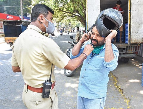 A police officer fines a motorist for not wearing a mask in Bengaluru. (Photo | Vinod Kumar T, EPS)