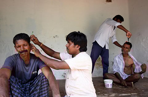 KP Mahadeva and his brother KP Siddaraju giving haircuts to villagers in Dalit villages (Photo | Express)